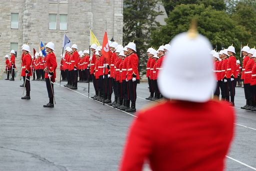 OCdts on parade in scarlet uniforms with white pith helmets