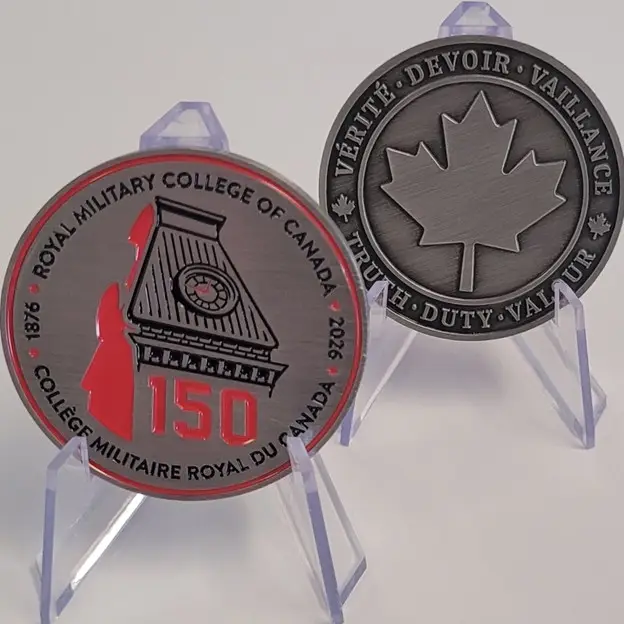 Deux pièces commémoratives présentées sur des socles. L'une porte l'inscription « Royal Military College of Canada 150 » et représente un bâtiment et un soldat. L'autre représente une feuille d'érable ainsi que les mots « Vérité Devoir Vaillance » et « Truth Duty Valour ».
