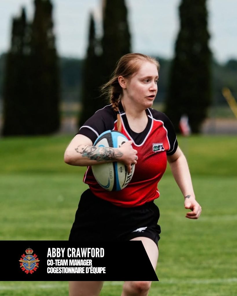 A female CAF Women’s Rugby player in a red and black jersey runs across a pitch holding a rugby ball above a black banner that reads “Abby Crawford, Co-Team Manager” with a crest.