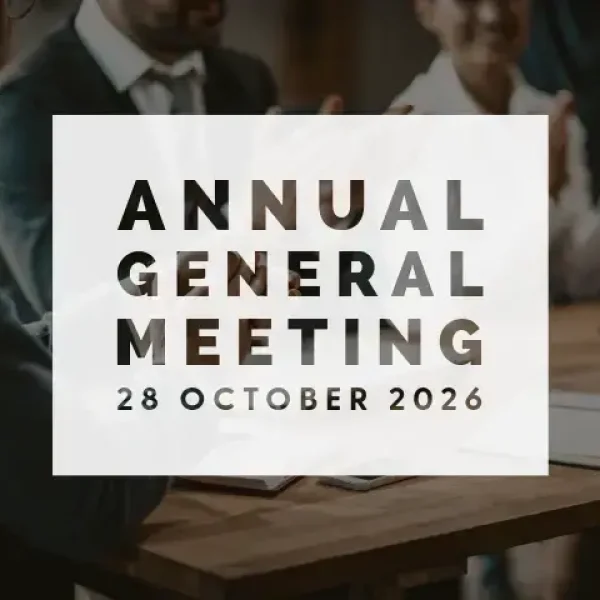 People applauding around a wooden table with a white overlay announcing “Annual General Meeting 28 October 2026” in bold text.