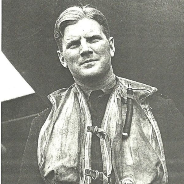A man in a military uniform wearing an inflatable life jacket.